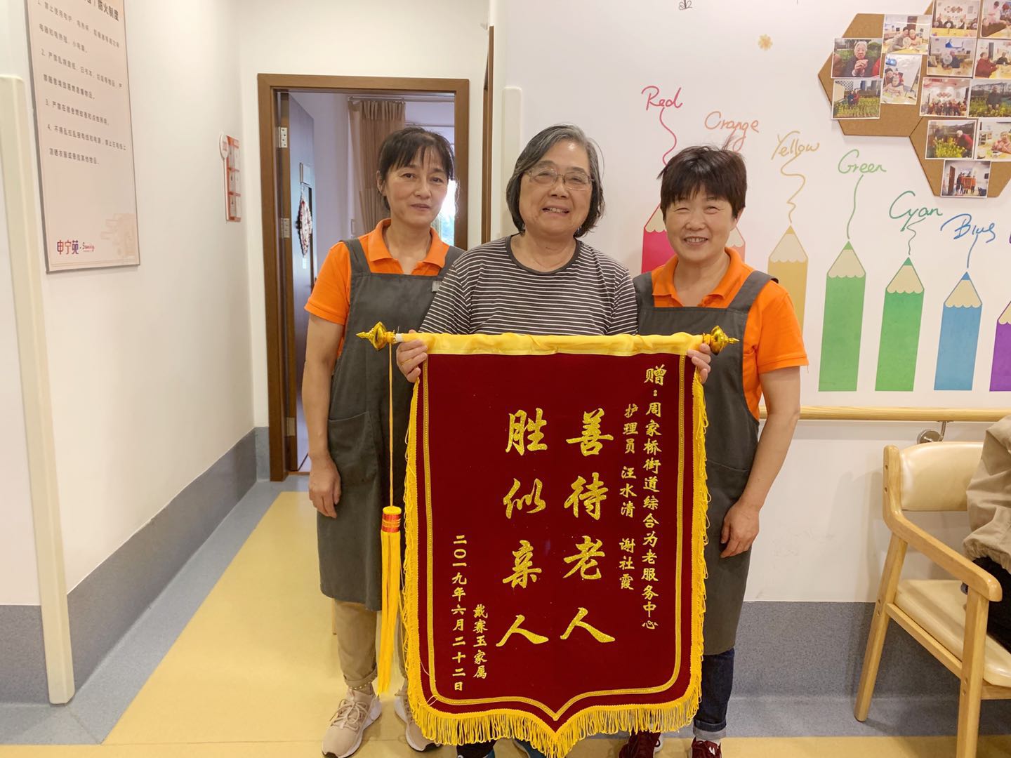 锦旗上写着"善待老人,胜似亲人"以感谢为老中心的两位护理员汪水清和